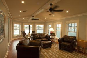 Large room with ceiling fans, seating, and windows