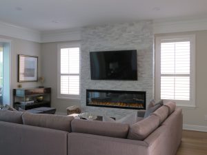 Large sectional couch in a family room with a fireplace and flat screen tv